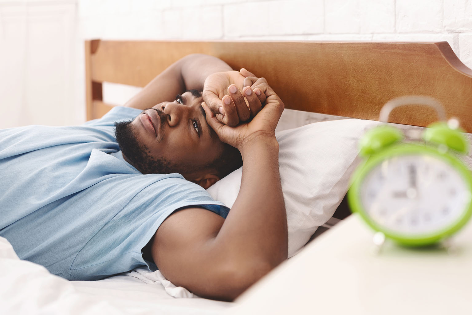 Black man in bed suffering from sleep disorder